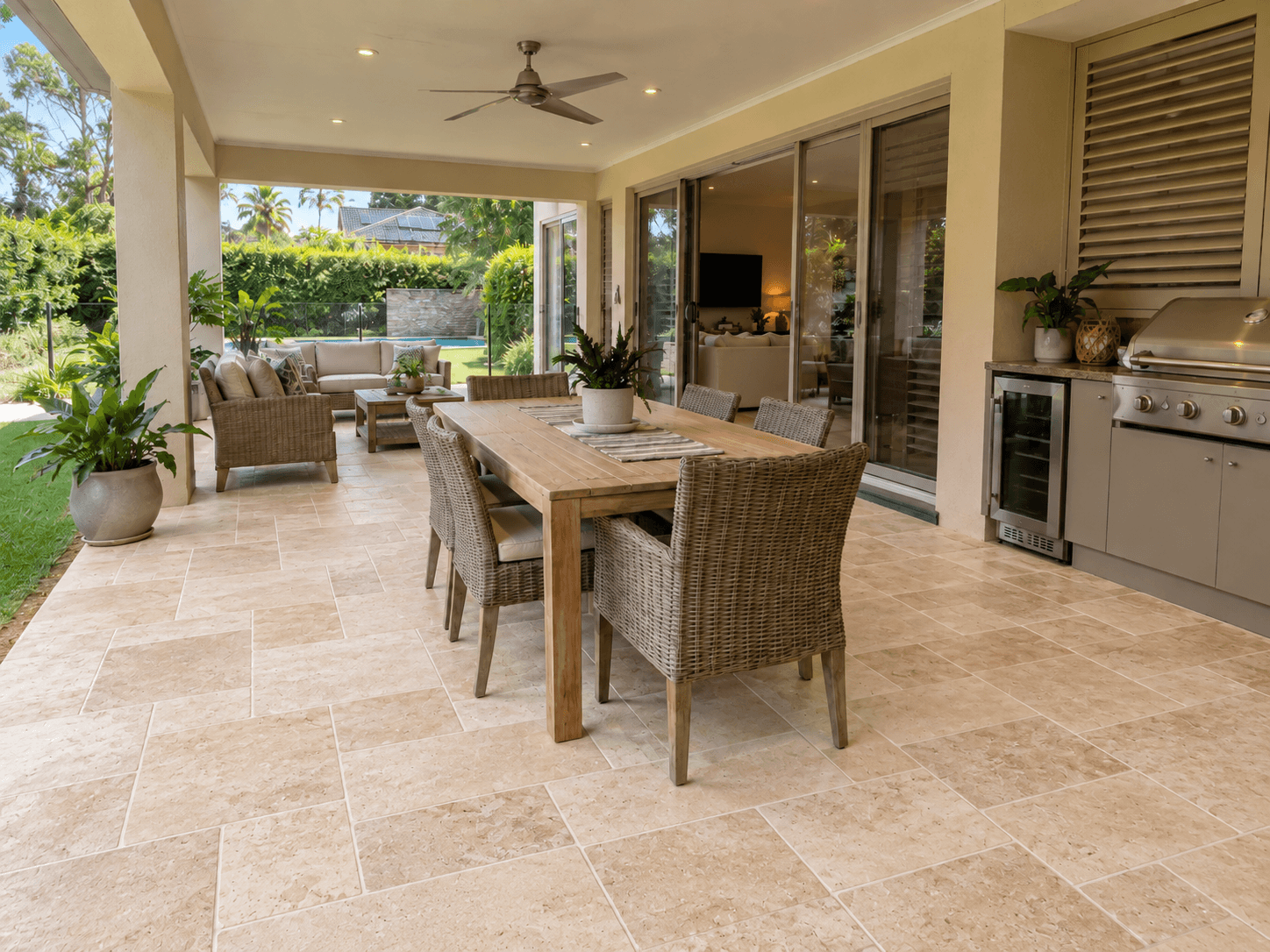 An alfresco floor, retiled. Worn terracotta out. Tumbled travertine-look pavers in, laid in a French pattern.