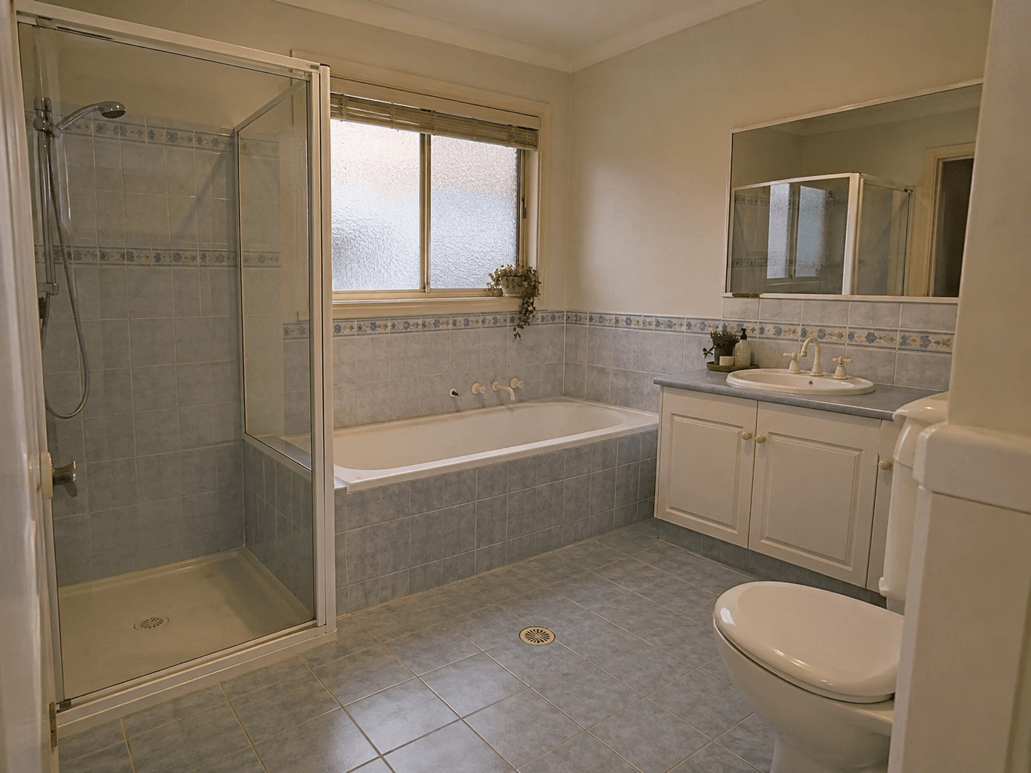 A dated blue-tiled bathroom before the plan